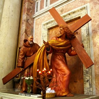 Padre_pio_giving_Jesus_a_hand_with_the_cross.JPG