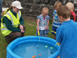 Toddlers enjoy a spot of 'fishing' with Aishling Donegan, at the Casting Day. Click on photo for the details.