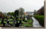 Old Graveyard in the foreground with McDonalds, Caseys, Tescos and Church of the Holy Rosary visible in the background