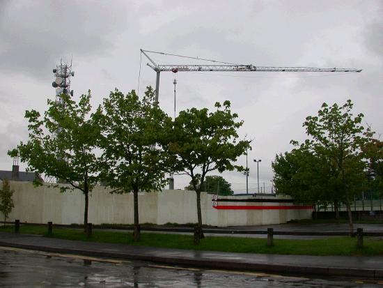 Behind the Hoarding brickwork is emerging from the foundations.