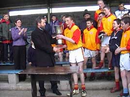Uachtaran CLG Sean Kelly presenting the Feile Trophy to Castlebar Mitchels Captain of the U14 Football Team on 3 May 2003