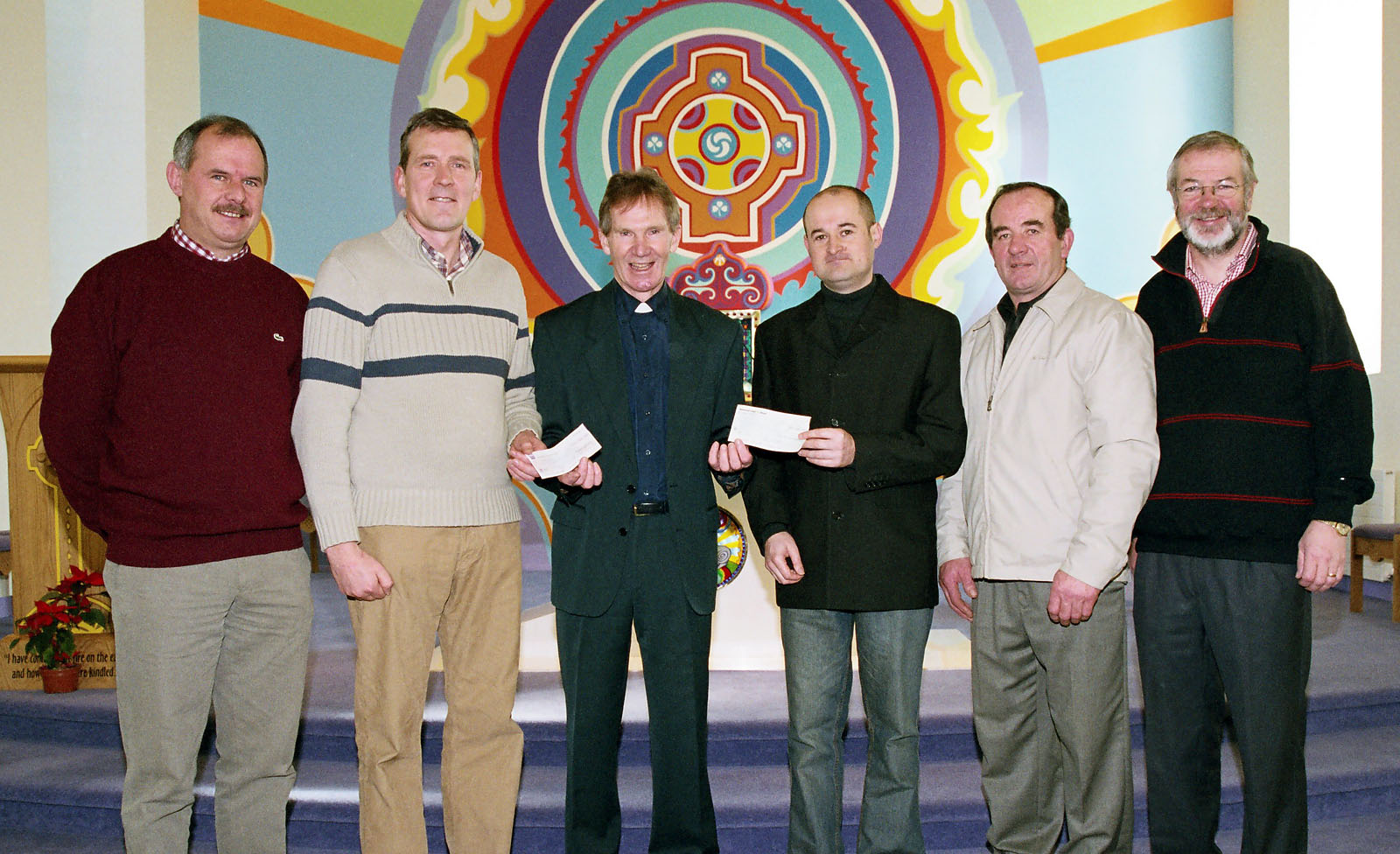 Pictured in Keelogues Church Fr. Peter Waldron (on behalf of Trocaire Asian Appeal) receiving cheques from Joe Barrett (Ballyvary Community Developing Company), and Padraig McDonnell (treasurer Ballyvary Blue Bombers). L-R: Harry Barrett, Noel Burke, Joe Barrett, Fr. Peter  Waldron, Padraig McDonnell, Andy Walsh, Michael Golden. Photo  Ken Wright Photography 2005. 
