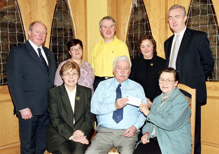 Pictured in the Welcome Inn Johnny Mee (Chairperson, Irish Emigrant Liaison Committee - Mayo Branch) accepts cheque from Sally Hopkins (Sec), Humbert Foundation. Front L-R: Agnes Waldron (Romanian Shop), Johnny Mee (Chairman MELC), Sally Hopkins (Rumanian Shop), Francis Brennan (MELC PRO), Nado Cafolla (MELC), James OMalley (MELC Secretary), Mary Kelly (Rumanian Shop),  Joe ODea (MELC). 
Photo  Ken Wright Photography 2004. 

