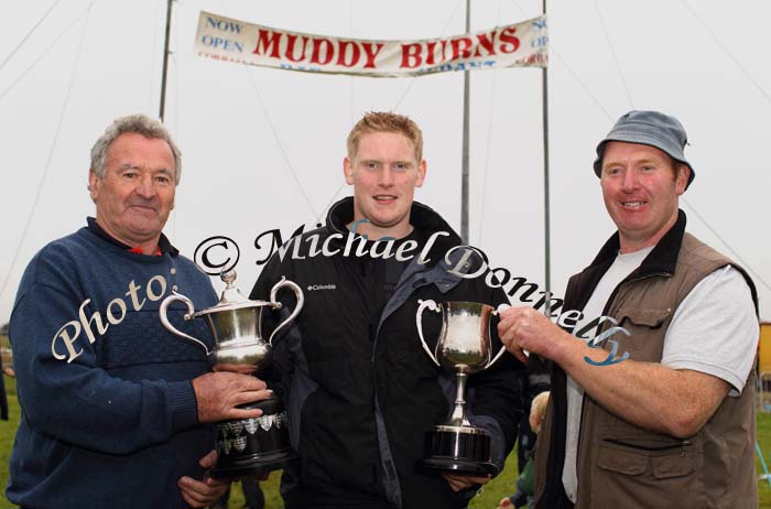 Ciaran Mullarkey, Bonniconlon  (centre) winner of the Senior Irish Championship Sheaf Tossing  is presented with the  Willie Fox Cup by Mick O'Malley and the Ballyman Cup for AllIreland U-21 Championship by John Greavy (on right) at Bonniconlon 61st Agricultural Show and Gymkhana . Photo: © Michael Donnelly