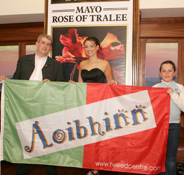Michael and Tara Baynes  from the Tweed Centre, Main St Castlebar present a flag to  Mayo Rose Aoibhinn Ní Shúilleabháin. Photo: Michael Donnelly.