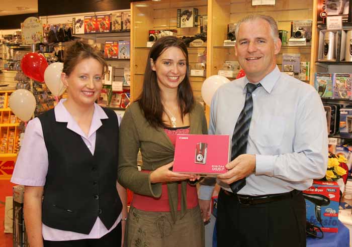 Pat Staunton presents a Canon IXUS i5 digital camera to Mayo Rose of Tralee Aoibhinn Ní Shúilleabháin, a former member of staff of Stauntons Photo Shop. Included in photo is Mary Moran manageress  Stauntons Digital One Hour Photo. Photo: Michael Donnelly.