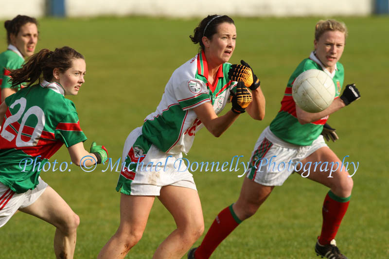 Michelle Walsh, St Brigids releases the ball as she comes under pressure from Carnacon's Nicole  Nestor and Claire Egan in the Tesco Connacht Ladies Gaelic Football Senior Club Championship final in Canon Gibbons Park Claremorris. Photo: © Michael Donnelly Photography