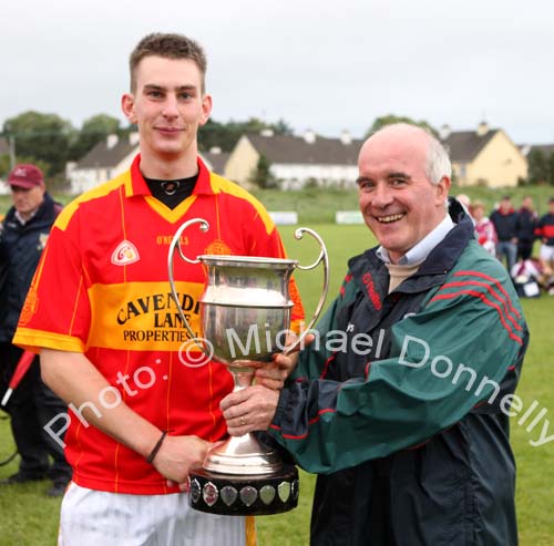 Barry Moran, captain Castlebar Mitchels U-21 team is presented with the Cup by Paddy McNicholas, Vice Chairman Mayo GAA Board, in the Ulster Bank U-21A County Football Championship final in Fr O'Hara Park Charlestown after defeating Crossmolina Deel Rovers. Photo:  Michael Donnelly