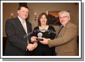 Geraldine Duffy is presented with an "Outstanding Service" Award by John O'Mahony (special guest) and John Caulfield, Chairman Bord na ng at the Kilmovee Shamrocks Ladies Gaelic Football Club annual Dinner in The Abbeyfield Hotel, Ballaghaderreen. Photo:  Michael Donnelly
