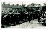Market Square, Castlebar. Showing the weighing scales and Forresters Hall. What year from Aidan Brett
